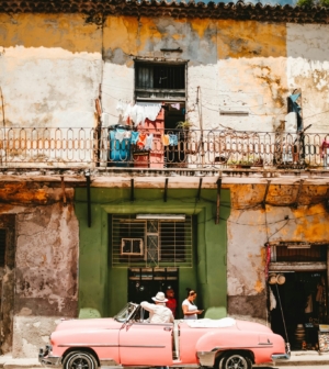 Pink car in front of a house in Cuba