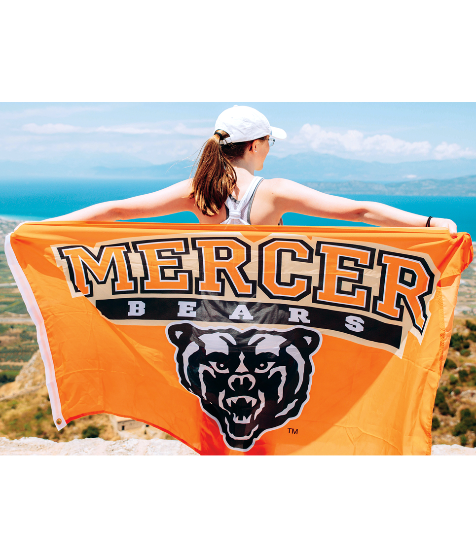 Student with Mercer Bears flag looking out over mountain