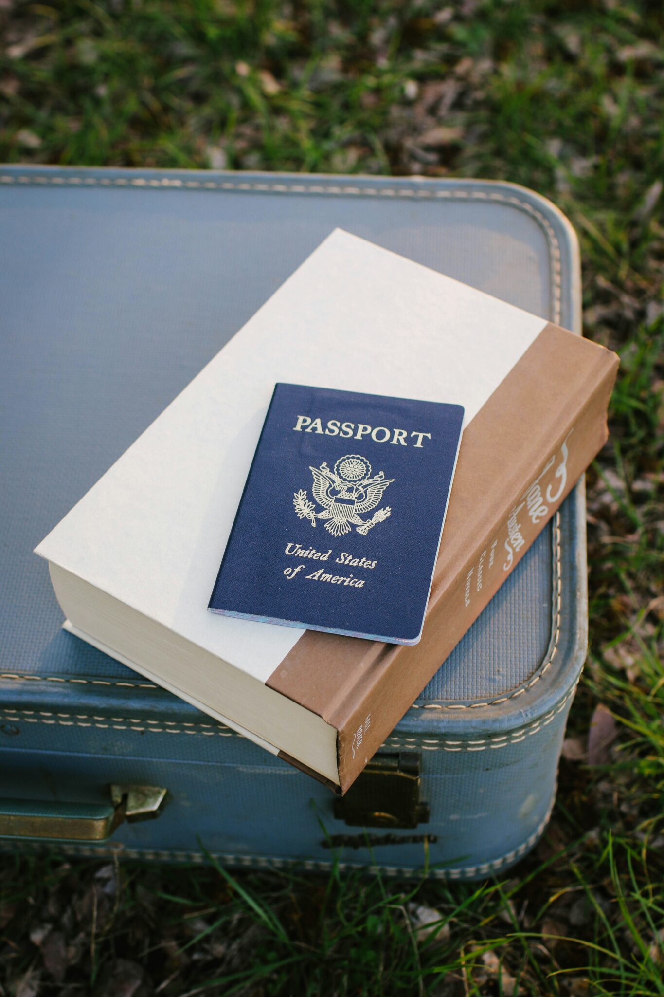 US Passport on top of book and suitcase