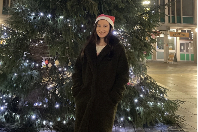 Photo of Samantha Homcy in front of christmas tree with Santa hat on